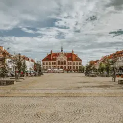 Ratusz i kolorowe kamienice na brukowanym rynku. Wspaniałe atrakcje turystyczne miasta, idealne na spacer.