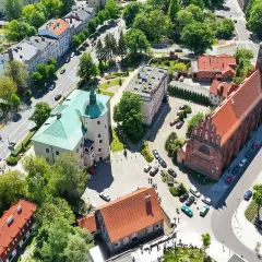 Słupsk atrakcje: widok z lotu ptaka na zamek Książąt Pomorskich z zielonym dachem i gotycki kościół.