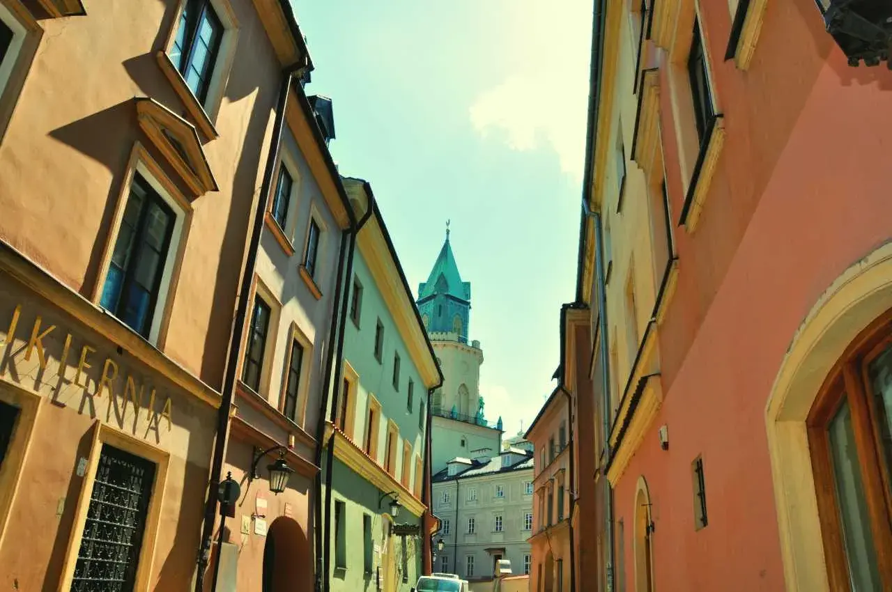 Ulica w Lublinie z kolorowymi kamienicami i wieżą. Może to być początek przygody w parku rozrywki Lublin.