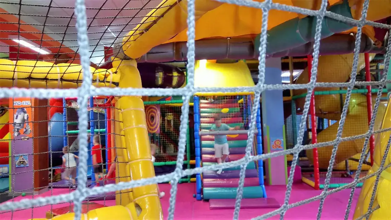 Kolorowy park rozrywki w Lublinie z R2-D2 na ścianie. Dzieci bawią się na zjeżdżalniach i w labiryncie.