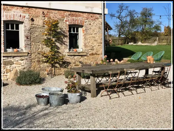 Rusty metal chairs await guests at a rustic table, perfect for enjoying the autumn charm of agroturystyka Dolny Śląsk.