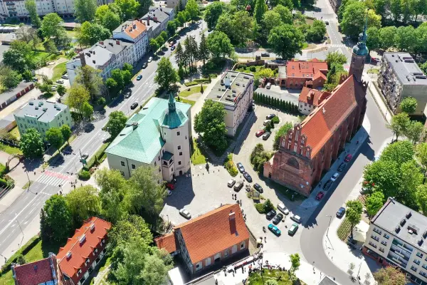 Słupsk atrakcje: widok z lotu ptaka na zamek Książąt Pomorskich z zielonym dachem i gotycki kościół.